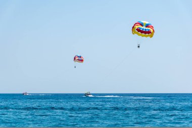 Parasailing üzerinde uçan insanlar ile iki hızlı tekneler (Rho paraşüt