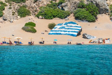 R Tsambika beach büyük Yunan bayrağı ile altın kum ile boyalı