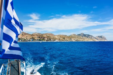 Yunan bayrağı görünümünü tekne ve Stegna beach behaind (Rhodes, Gre
