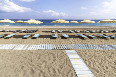 Faliraki yakınlarındaki Afandou sahilinde boş güneşlik ve şemsiye (Rhode