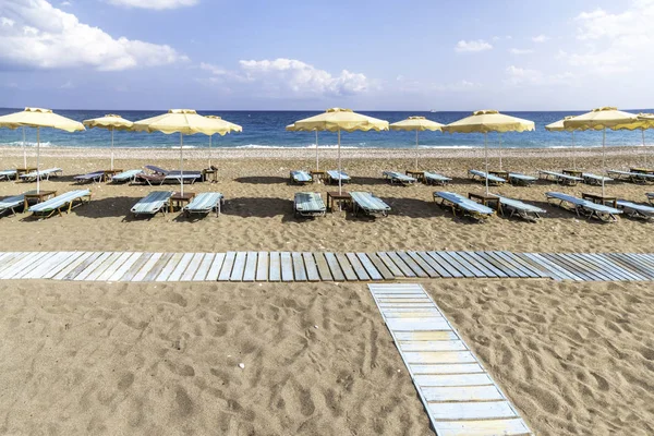 Faliraki yakınlarındaki Afandou sahilinde boş güneşlik ve şemsiye (Rhode