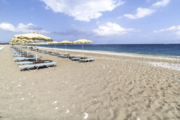 Faliraki yakınlarındaki Afandou sahilinde boş güneşlik ve şemsiye (Rhode