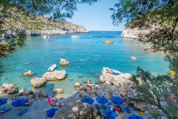Pequeña playa con turistas, sombrillas y tumbonas en Anthony Quinn (Rodas, Grecia) ) — Foto de Stock
