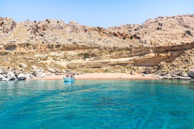 Kızıl Kum Sahili kıyısında demirli turizm teknesi (Rodos, Yunanistan)