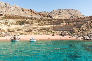 Kızıl Kum plajında demirleyen turist tekneleri, insanlar eğleniyor (Rodos, Yunanistan)