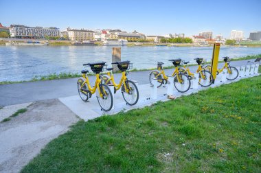 BRATISLAVA (SLOVAKIA) 20 Nisan 2020: Sarı halk bisikletleri Tuna Nehri kıyısındaki liman istasyonunda kilitli 