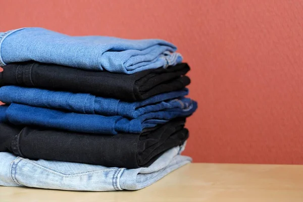Jeans coloridos são ordenadamente empilhados — Fotografia de Stock