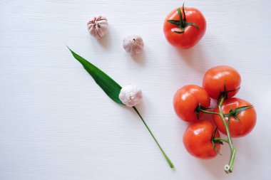 Yaprak otlar ve Beyaz ahşap zemin üzerinde domates sarımsak  