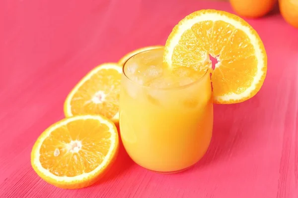 Апельсиновый сок на розовом фоне — стоковое фото