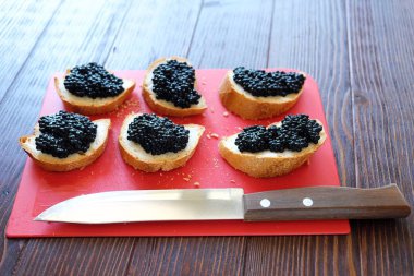 Siyah havyar ve ahşap zemin üzerine ekmek