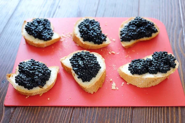 Siyah havyar ve ahşap zemin üzerine ekmek