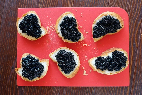 Siyah havyar ve ahşap zemin üzerine ekmek