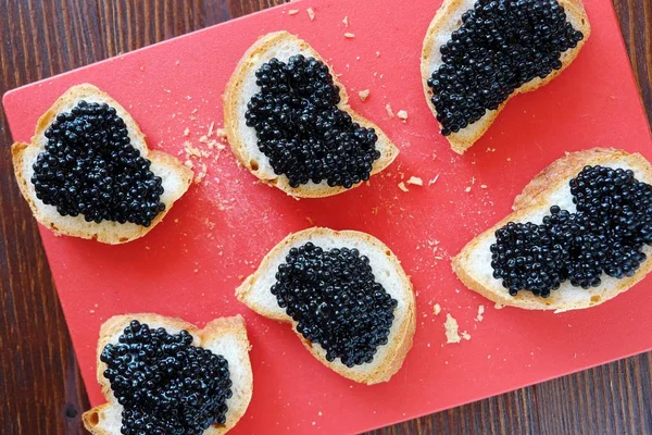 Siyah havyar ve ahşap zemin üzerine ekmek