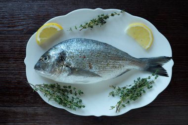 Limon ve kekik bir plaka üzerinde taze balık