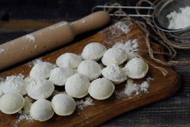 Ev yapımı mantı ve un bir ahşap tahta üzerinde 