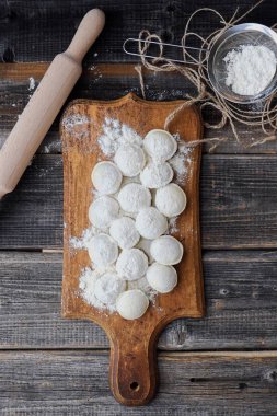 Ev yapımı mantı ve un bir ahşap tahta üzerinde 