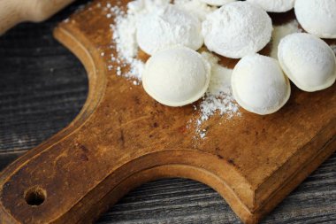 Ev yapımı mantı ve un bir ahşap tahta üzerinde 