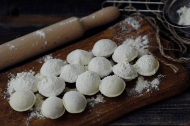 Ev yapımı mantı ve un bir ahşap tahta üzerinde 