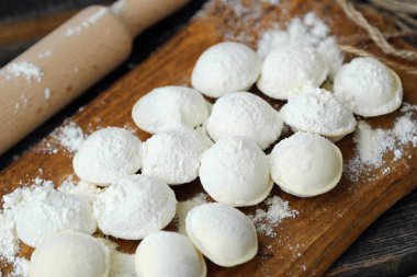 Ev yapımı mantı ve un bir ahşap tahta üzerinde 