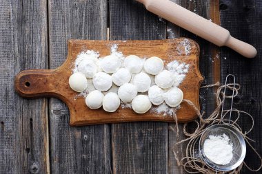 Ev yapımı mantı ve un bir ahşap tahta üzerinde 