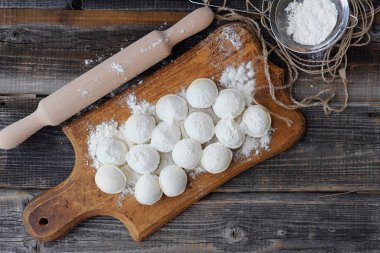 Ev yapımı mantı ve un bir ahşap tahta üzerinde 