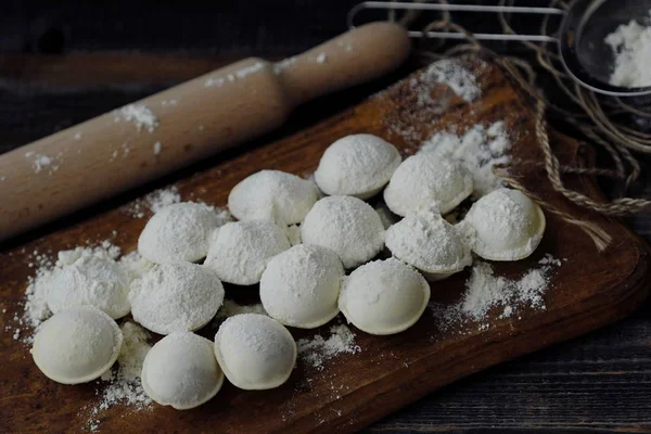 Ev yapımı mantı ve un bir ahşap tahta üzerinde 