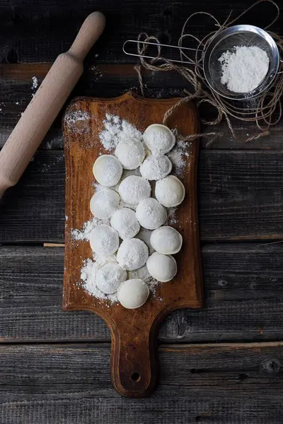 Ev yapımı mantı ve un bir ahşap tahta üzerinde 