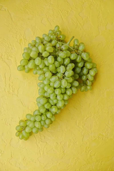 在黄色背景上的新鲜绿葡萄 — 图库照片
