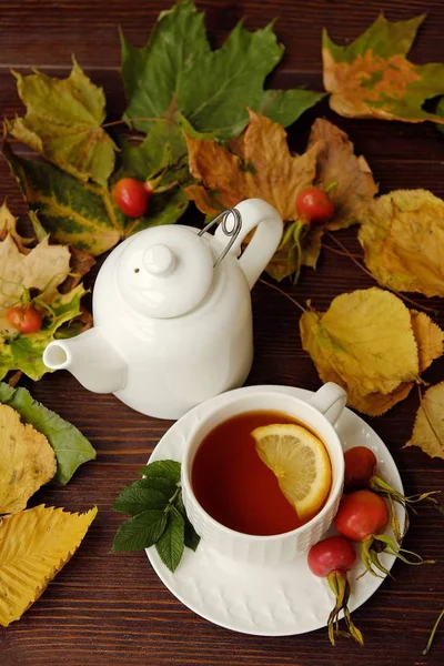 Té con limón en la mesa con hojas de otoño — Foto de Stock