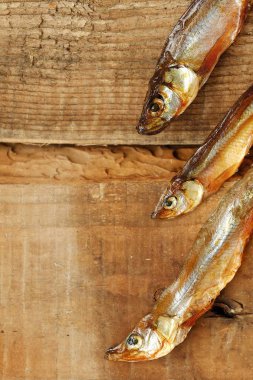 Ahşap zemin üzerine tuz ile kurutulmuş balık 