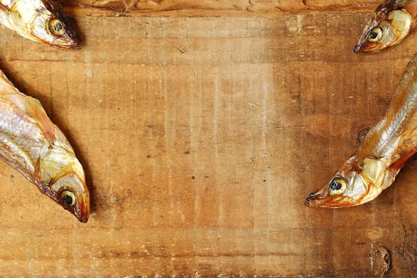 Ahşap zemin üzerine tuz ile kurutulmuş balık 