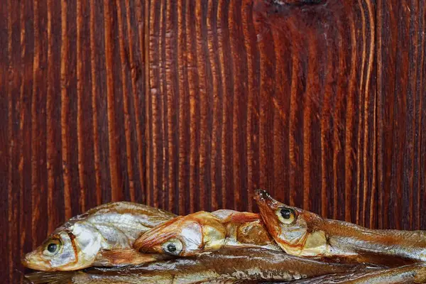 Torkad fisk med salt på trä bakgrund — Stockfoto