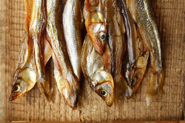 Ahşap zemin üzerine tuz ile kurutulmuş balık 