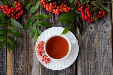 Lezzetli bardak çay ve üvez meyveleri ahşap bir masa üzerinde 