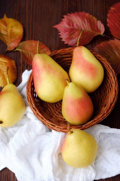 Sulu olgun sarı armut ve ahşap bir masa içinde sonbahar yaprakları 