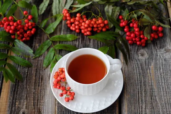 Lezzetli bardak çay ve üvez meyveleri ahşap bir masa üzerinde 
