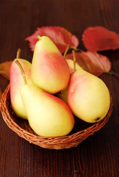 Sulu olgun sarı armut ve ahşap bir masa içinde sonbahar yaprakları