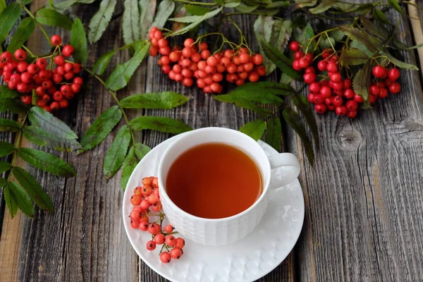 Lezzetli bardak çay ve üvez meyveleri ahşap bir masa üzerinde   