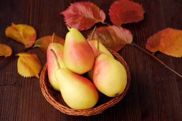 Sulu olgun sarı armut ve ahşap bir masa içinde sonbahar yaprakları