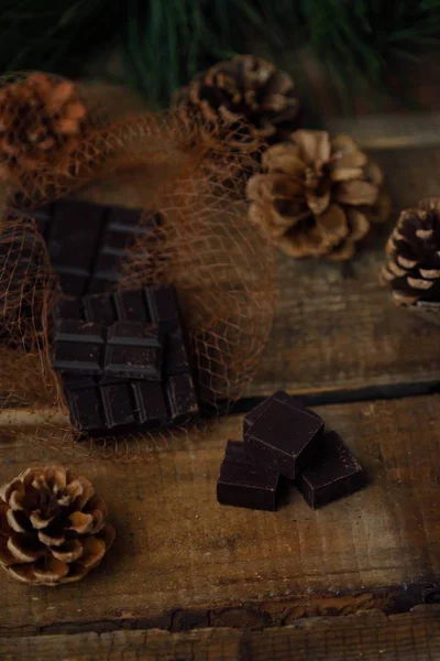 Fundo de madeira de Natal com chocolate e pinho — Fotografia de Stock