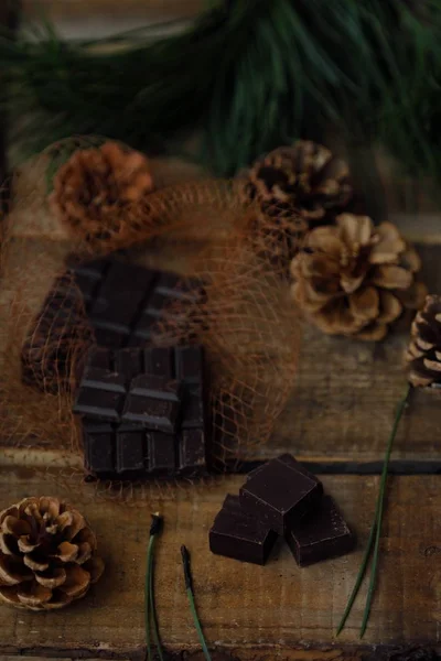 Fundo de madeira de Natal com chocolate e pinho — Fotografia de Stock