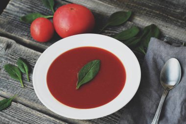 Lezzetli soğuk domates çorbası ve otlar masada