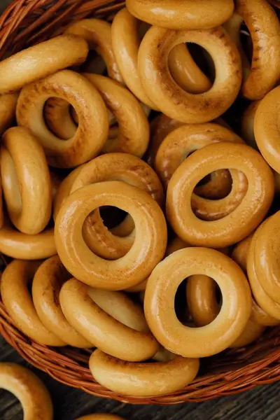 Tasty bagels in basket on wooden table — Stock Photo, Image