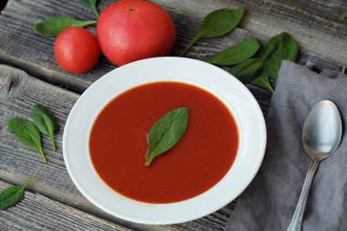 Lezzetli soğuk domates çorbası ve otlar masada