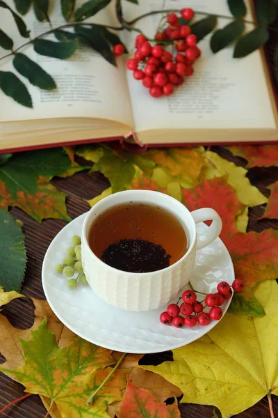 Earl grey tea with book and rowan on the table