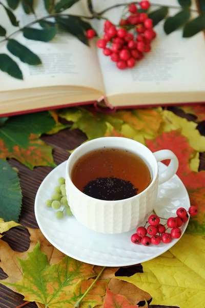 Earl grey tea with book and rowan on the table