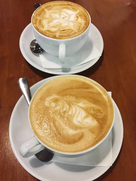 Dwie filiżanki cappuccino pyszne na stole — Zdjęcie stockowe