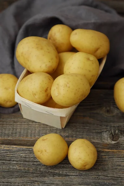 Leckere frische Kartoffeln in einem Holzkorb auf dem Tisch — Stockfoto