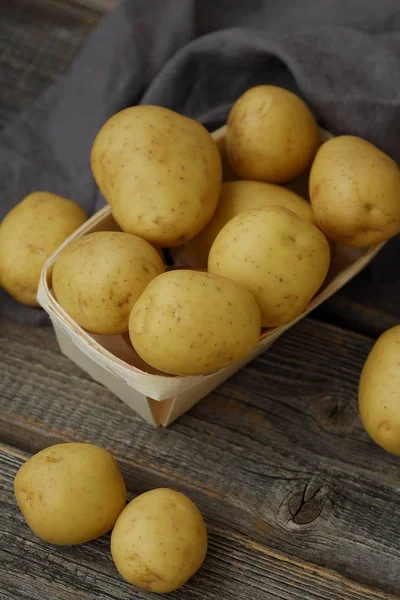 Leckere frische Kartoffeln in einem Holzkorb auf dem Tisch — Stockfoto