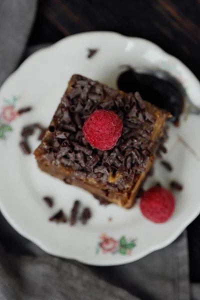 Pyszne ciasto czekoladowe z malinami na stole — Zdjęcie stockowe